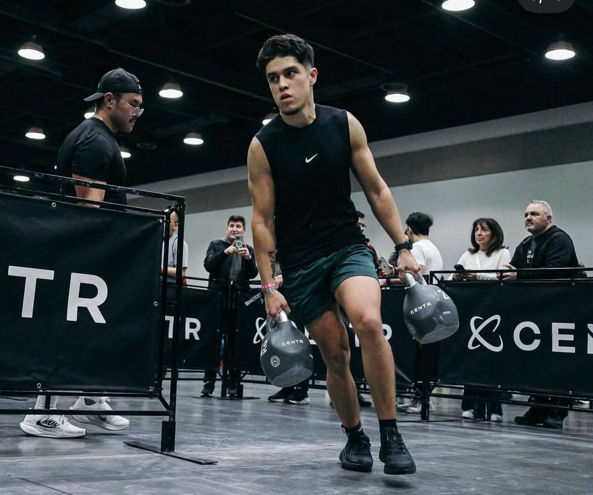 Coached kettlebell farmers carry on the HYROX floor